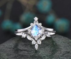 an engagement ring with a pear shaped blue topazte surrounded by diamonds