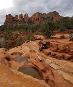 a person sitting on top of a rock formation