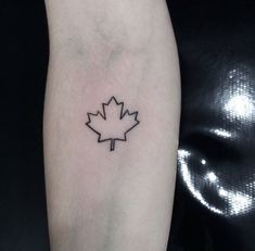 a black and white photo of a canadian maple leaf tattoo on the left arm,