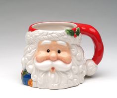 a ceramic santa clause mug with a red handle