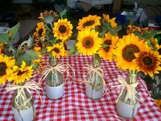 sunflowers in mason jars on a checkered tablecloth