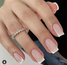 a woman's hand with french manies and a wedding ring on her finger