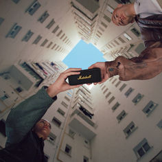 two people holding up a cell phone in front of a building