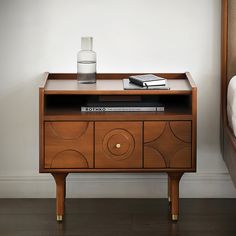 a bedside table with books and a glass on top