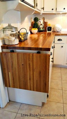 a kitchen with white cabinets and wooden counter tops