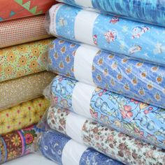 a stack of colorful fabrics on display in a store