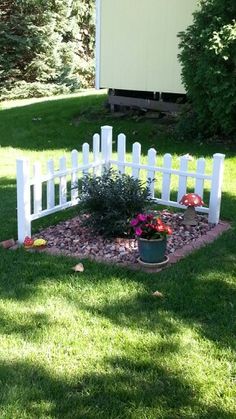 a white picket fence sitting in the middle of a yard