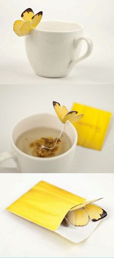 a cup of tea with two butterflies on it and a yellow envelope in the middle