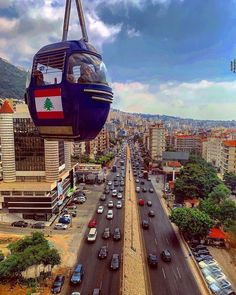 an overhead view of a city with cars and a cable car in the middle of it