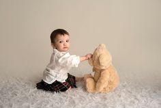 a baby is playing with a teddy bear