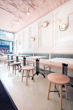 tables and chairs are lined up against the wall in an empty room with exposed ceilings