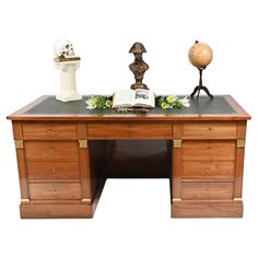 an antique desk with a book, globe and other items on it's top