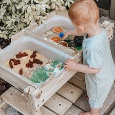 a little boy that is standing in front of a table with food inside of it