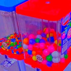 two plastic bins filled with lots of different colored gummy balls and one has a red lid