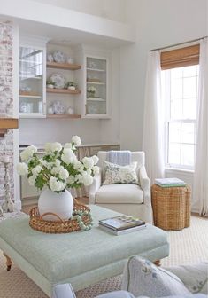 a living room filled with furniture and a fire place covered in white flowers on top of a coffee table