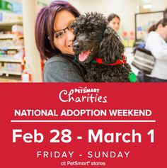 a woman holding a black dog in her arms at the petmart charity's national adoption weekend