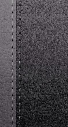 black leather texture with stitching on the side and white stitching down the middle