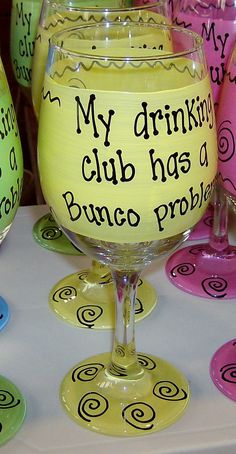 a table topped with wine glasses filled with liquid and writing on the glass, next to each other