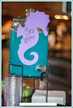 there is a blue beverage dispenser with a purple sea horse on it