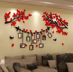 the living room is decorated with red flowers and pictures hanging on the wall above the couch