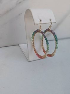 Multi Color Rainbow Crystal Hand Wire Wrapped Hoops.  Gold plated wire and gold plated ear wires. 4mm beads around medium sized hoop that measures 1.75 inches Earring hangs 2 inches Hoop hangs vertically - the entire circle faces sideways Wrapped Hoop Earrings, Circle Face, Triple Wrap Bracelet, Hoops Gold, Earrings Colorful, Color Rainbow, Rainbow Crystal, Peach Moonstone, Polish Jewelry