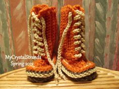 a pair of crocheted boots sitting on top of a wooden table