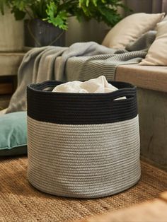 a basket sitting on the floor next to a couch