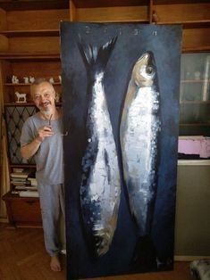 a man standing next to a painting of two fish