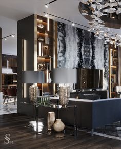 a modern living room with black and white decor on the walls, large chandelier