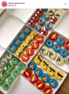 four boxes filled with decorated cupcakes on top of a table