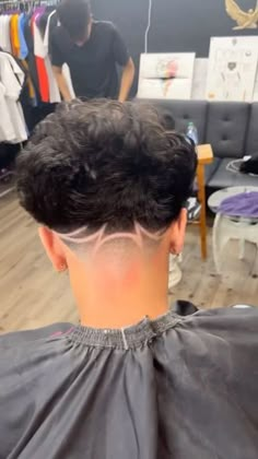 a man getting his hair cut in a barbershop with another person behind him