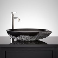 a black bowl sink sitting on top of a counter