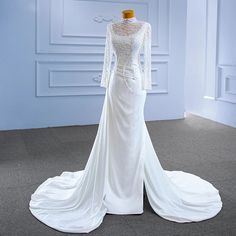 a white wedding dress on display in a room