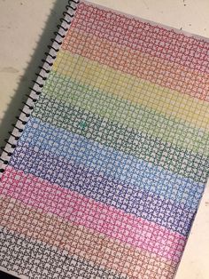 a colorful notebook sitting on top of a table next to a pen and paper towel