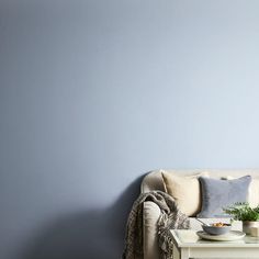 a living room with blue walls and a white coffee table in front of the couch