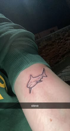 a man's arm with a tattoo of a shark on the left side of his arm