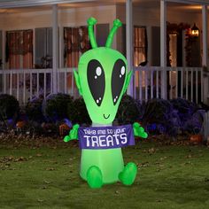 an inflatable alien holding a sign that says, that's not your treats