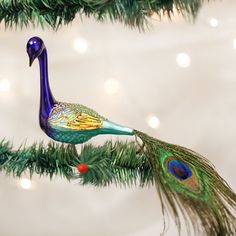 a peacock ornament hanging from a christmas tree