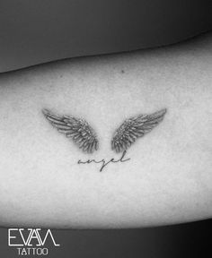 an angel wing tattoo on the arm with words written below it in cursive writing