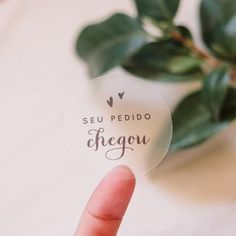 someone holding up a sticker that says seu pedido chegou