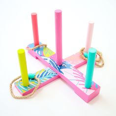 four colorful candles are tied to ropes on a white surface, with one candle in the middle