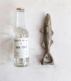 a bottle opener next to a metal fish