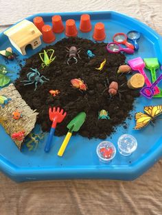 a child's play tray filled with dirt and toys