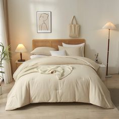 a bed with white sheets and pillows in a bedroom next to a lamp on the floor