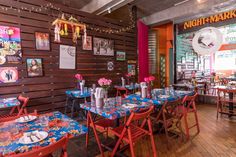 a restaurant with tables and chairs covered in blue tablecloths, decorated with pictures on the wall