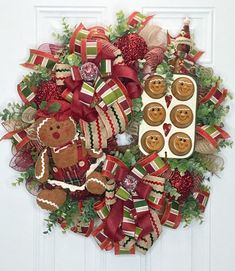 a christmas wreath with teddy bears and cupcakes hanging on the front door,