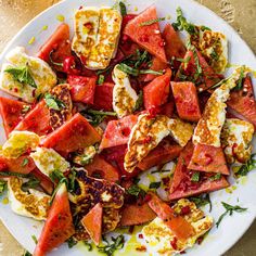 a white plate topped with sliced up tomatoes and hard boiled egg shells on top of watermelon