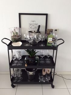 a bar cart filled with wine glasses and bottles