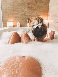 a woman laying in a bathtub with foam on it