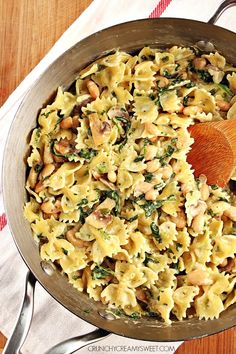 pasta with spinach, chickpeas and pine nuts in a silver pan on a red and white towel